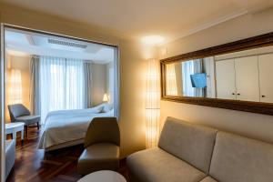 a hotel room with a bed and a mirror at Hotel des Balances in Lucerne