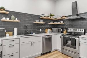 a kitchen with white cabinets and stainless steel appliances at Carriage House Loft - King Bed and Garage Parking in Buffalo