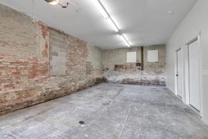 an empty room with a brick wall at Carriage House Loft - King Bed and Garage Parking in Buffalo