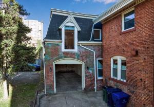 a red brick house with an open garage at Carriage House Loft - King Bed and Garage Parking in Buffalo