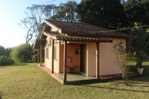 a small brick building with a porch in a yard at Recanto das Seriemas in Patrimônio São Sebastião