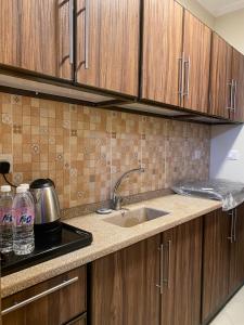 a kitchen with wooden cabinets and a sink at شقه ١١٢٢ في ابراج التلال بمكه المكرمه in Makkah