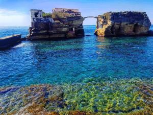 a large body of water with a rock formation at Romeo house in Naples +14 photos