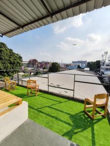 a patio with chairs and grass on a roof at Youyen Hostel in Ban Don Muang