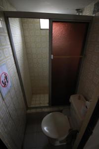 a bathroom with a toilet and a glass shower door at Pachamac House in Guayaquil