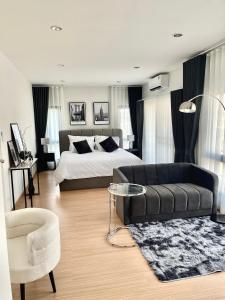 1 dormitorio con cama, sofá y mesa en BBighouse, en Ban Yang Plao