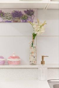 wazon z kwiatami na półce obok zlewu w obiekcie Mapo Hongdae Detached Home w Seulu