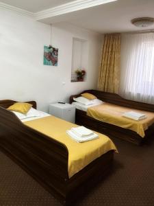 a hotel room with two beds with yellow sheets at Motel Potcoava de Aur in Alexandria