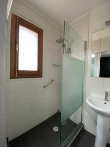uma casa de banho com uma cabina de duche em vidro e um lavatório. em Hotel Boutique Tremo Bellavista Suite em Santiago