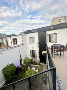 einen Balkon in einem weißen Gebäude mit einem Tisch und Stühlen in der Unterkunft Hotel Boutique Tremo Bellavista Suite in Santiago