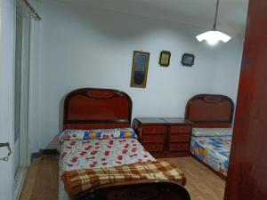 a bedroom with two beds and two night stands at The sea apartment in ‘Izbat al Qaşr