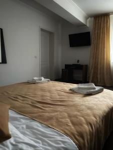 a bedroom with a large bed with two towels on it at Motel Potcoava de Aur in Alexandria