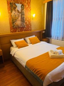 sypialnia z dużym łóżkiem z pomarańczowymi poduszkami w obiekcie Lebon Hotel-Special Class w Stambule
