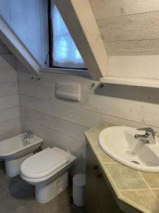 y baño con aseo y lavamanos. en MONOLOCALE STELLALPINA - PONTE DI LEGNO-, en Ponte di Legno