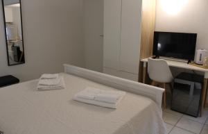 una camera da letto con un letto con due asciugamani sopra di Tulip Rooms a Catania Altre 10 foto