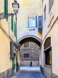a person walking down a street in an alley at Lovely Apartment near Piazza della Signoria in Florence