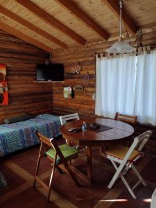 Habitación con mesa, cama y dormitorio. en Cabaña Sonnentahl 2, en Potrerillos