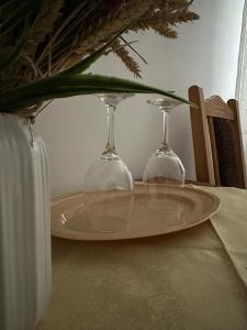 dos copas de vino sentadas en una mesa con un jarrón en Motel Potcoava de Aur en Alexandria