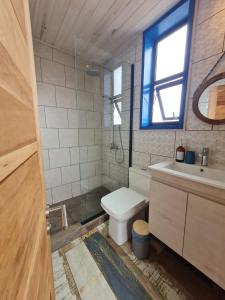 uma casa de banho com um WC, um lavatório e uma janela em Cabaña con jacuzzi campo mar em Matanzas