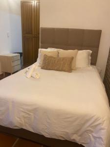 1 dormitorio con 1 cama grande con sábanas y almohadas blancas en hotel Atabal 