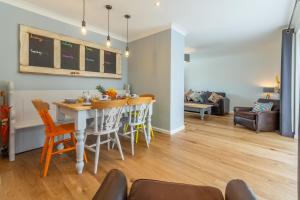 a dining room and living room with a table and chairs at One Lazy Duck in Heacham