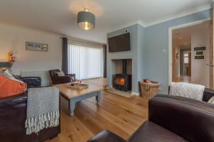 a living room with a couch and a table and a fireplace at One Lazy Duck in Heacham