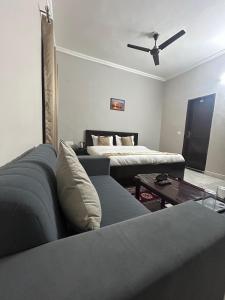 uma sala de estar com um sofá e uma cama em RAJ RESIDENCY em Gurgaon