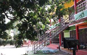 a person walking past a building with a staircase at Rainbow holiday home in Kalpetta
