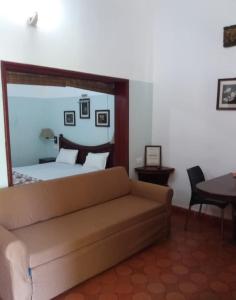 a living room with a couch and a bed at Rainbow holiday home in Kalpetta