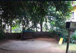 a park with a tree and a fence at Rainbow holiday home in Kalpetta