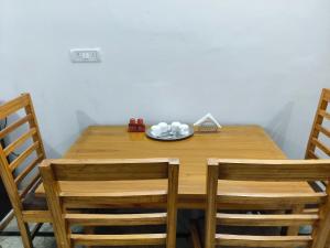 einem Holztisch mit zwei Stühlen und einem Teller darauf in der Unterkunft Pran Prasadam in Ayodhya