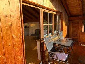 - une salle à manger avec une table et des chaises dans une cabine dans l'établissement Apartment mit Zugspitzblick, à Grainau