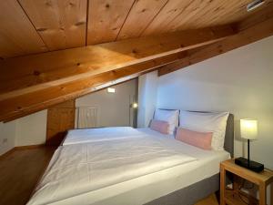 Cette chambre dispose d'un grand lit et de plafonds en bois. dans l'établissement Apartment mit Zugspitzblick, à Grainau