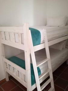 a white bunk bed with a green blanket on it at Braeside 14 in Cape Town