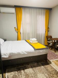 sypialnia z łóżkiem z żółtymi zasłonami i stołem w obiekcie Lebon Hotel-Special Class w Stambule