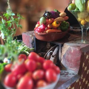 a bowl of fruit and vegetables on a table at Sitio Alecrim Gastronomia e Hospedaria in Alagoa