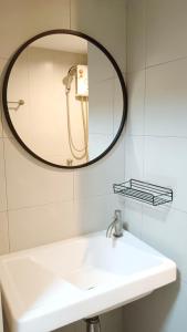 a bathroom with a sink and a mirror at Elio Sukhumvit 64: Chic Space in Bangkok