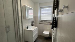 a bathroom with a sink and a toilet and a window at Holiday Residenz Alter Leuchtturm in Borkum +13 photos