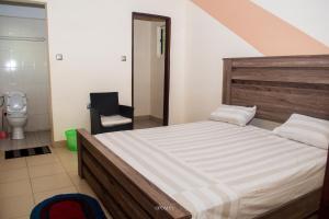 a bedroom with a large bed and a toilet at EAGLE in Ouéto