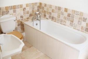 a bathroom with a tub and a toilet and a sink at Gorgeous Cottage by the sea sleeps 10 5 bed 4 bath in Heacham +21 photos