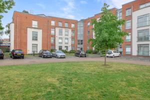 um parque de estacionamento com carros estacionados em frente aos edifícios em Spacious 2 bedroom apartment opposite QMC Hospital em Nottingham