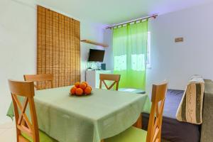 a dining room with a table with a bowl of fruit on it at Apartments Filipovic, 3 min walk to the beach in Split