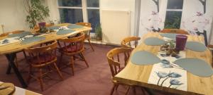 a room with long wooden tables and chairs at Pension Waldidyll in Stützerbach