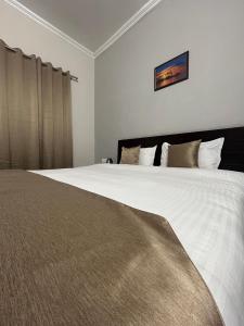 um quarto com uma cama grande com lençóis brancos e almofadas em RAJ RESIDENCY em Gurgaon