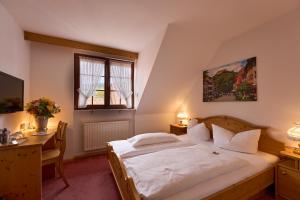 a bedroom with a bed and a desk and a window at Hotel der Löwen in Staufen in Staufen im Breisgau