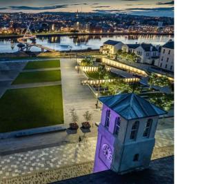 a purple building with graffiti on it next to a river at Skyview retreat in Derry Londonderry