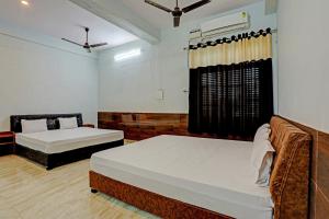 1 dormitorio con 2 camas y ventana en Nidhivan Guest House en Kishangarh