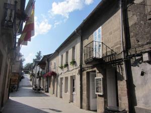 una calle vacía en un edificio antiguo con balcón en Casa Taboada, en Sarria