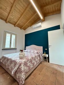 um quarto com uma cama e uma parede azul em Guest House il Il Podestà em Garbagna