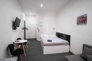 a bedroom with a bed and a table and a tv at Revolution Aparts - Rewolucji 27 in Łódź
